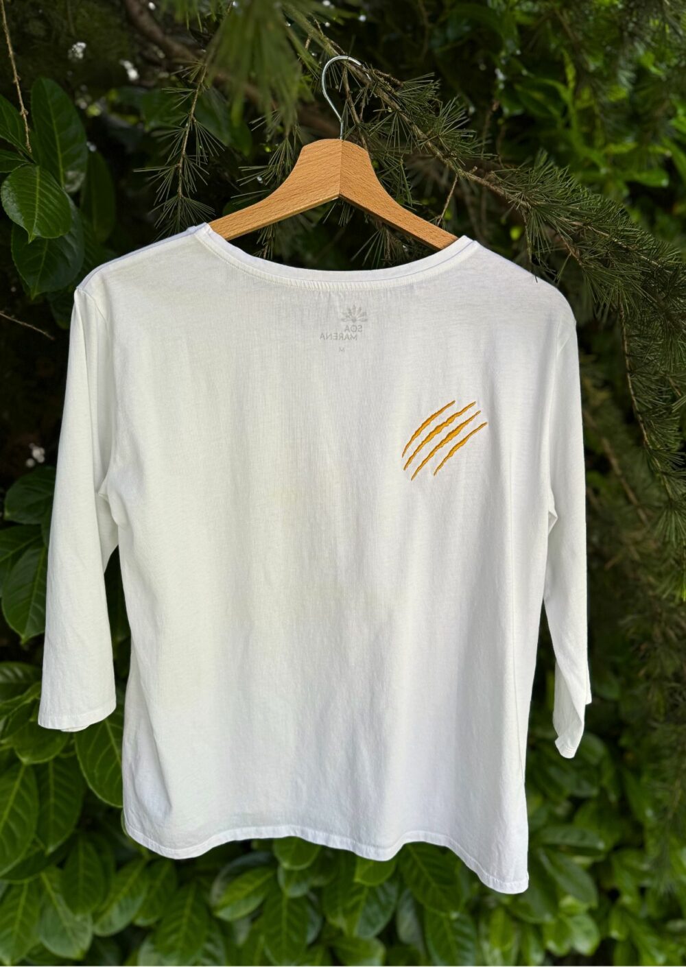 Tee-shirt manches 3/4 à col rond. Motif brodé lettres Féline avec griffe brodée. 100% coton biologique, confectionné au Portugal. Coupe évasée et fentes sur le côté. Grammage 150 gr/m2. Colori blanc.