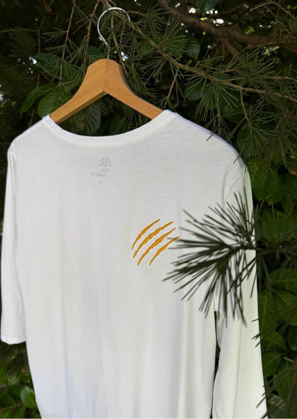 Tee-shirt manches 3/4 à col rond. Motif brodé lettres Féline avec griffe brodée. 100% coton biologique, confectionné au Portugal. Coupe évasée et fentes sur le côté. Grammage 150 gr/m2. Colori blanc.