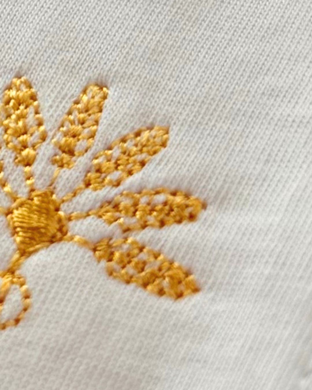 Gros plan de la broderie dorée du logo Soamarena